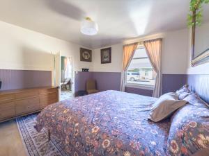 a bedroom with a bed and a dresser and a window at Historic Rock House in Helper