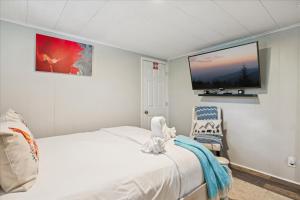 ピジョン・フォージにあるHoneycombs Suite with Hot Tub! Pigeon Forge TNのベッドと壁にテレビが掛かった寝室