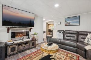 ピジョン・フォージにあるHoneycombs Suite with Hot Tub! Pigeon Forge TNのリビングルーム(革張りのソファ、薄型テレビ付)
