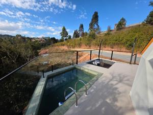 a swimming pool on the roof of a house at Refúgio Kuri'y Campos do Jordão in Campos do Jordão