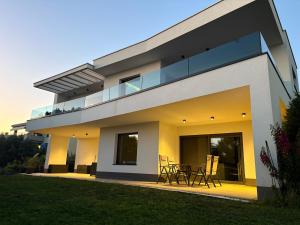 a modern house with a balcony and a table at Apartment Villa Anima in Kostrena