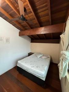 a small bed in a room with a ceiling at Pousada Pérolas de Peruíbe in Peruíbe +6 photos