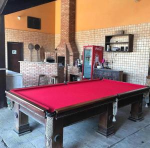 a pool table in a kitchen with a refrigerator at Pousada Pérolas de Peruíbe in Peruíbe