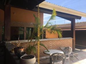 a patio with a table and chairs and plants at Pousada Pérolas de Peruíbe in Peruíbe