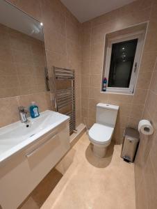 a bathroom with a white toilet and a sink at Spacious 3 bedroom house with games room in Kirby Muxloe +41 photos
