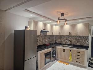 a kitchen with a refrigerator and a stove at Staycation Yakout in Mansouria