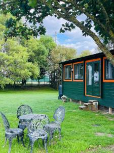 a table and chairs in front of a tiny house at Walland Cottage Romney Retreat in Old Romney