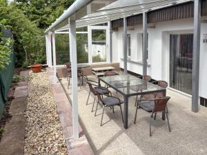 a patio with a glass table and chairs at Zur Teufelsmauer in Vorwerk Helsungen