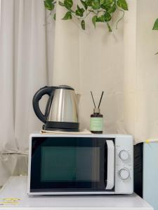 een magnetron met een waterkoker erop bij Ahyeon Station 10-minute walk Cozy Stay in Seoul