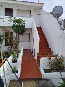 a stairway leading up to a white house with a staircase at Departamento para 5 personas en Mar De Ajó in Mar de Ajó
