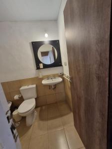 a bathroom with a toilet and a sink and a mirror at Pindó II - Expresión de buen gusto in Concordia