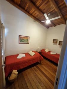 a room with two beds and a ceiling fan at Pindó II - Expresión de buen gusto in Concordia