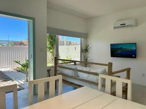 a living room with a couch and a table and chairs at RUBITO Gostosa casa de kite in São Miguel do Gostoso