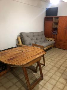 a living room with a couch and a wooden table at Dpto Lupe Beach in Villa Gesell +4 photos