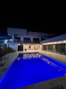 una gran piscina azul en un edificio por la noche en Hotel Rizuna by empire, en Paramaribo