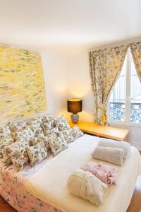a bedroom with a large bed with pillows and a window at Spacious Apartment in Montparnasse in Paris