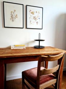 a wooden desk with a chair and two pictures on the wall at Suite D in Bad Dürkheim +7 photos