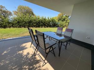 a table and chairs on a patio with a view of a yard at Apartment Villa Anima in Kostrena
