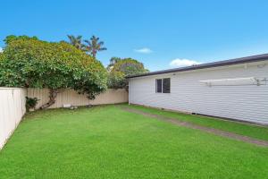 a backyard with a fence and a white garage at Beach Shack No. 5 in Crescent Head +3 photos