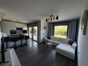 Una sala de estar con un sofá blanco y una cocina. en Apartment Villa Anima, en Kostrena