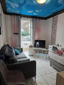 a living room with a blue ceiling and a couch at MONACO 3mn du casino in Beausoleil