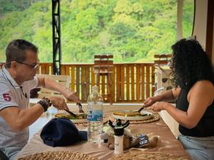 a group of people sitting at a table eating food at Montes De Beraka in Minca