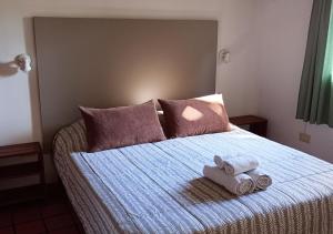 Un dormitorio con una cama con toallas. en Robles Federacion, en Federación
