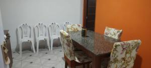 a dining room with a table and chairs at Casarão 3 quartos com ar e garagem in Belém