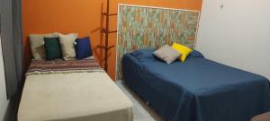 two beds sitting next to each other in a room at Casarão 3 quartos com ar e garagem in Belém