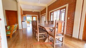 a dining room with a wooden table and a brick wall at Casa ampla em Mairinque com lazer completo in Mairinque