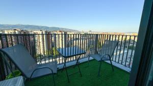 two chairs and a table on a balcony with a view at City View 1BR - Central Skopje - Free Parking in Skopje