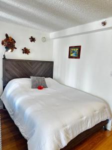 Un dormitorio con una cama blanca con una flor roja encima. en Studio for 4 people with Pool Jacuzzi Sauna BBQ, en Honolulu