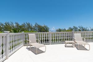 two chairs on a porch with a fence at Sundowner Villa villa in Savannah Sound