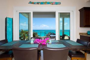 una sala da pranzo con tavolo e vista sull'oceano di Aqua Villa and Cottage home a Governorʼs Harbour