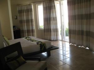 ガバナーズ・ハーバーにあるSky Beach Club Bungalow cabinのベッドとソファと窓のある寝室