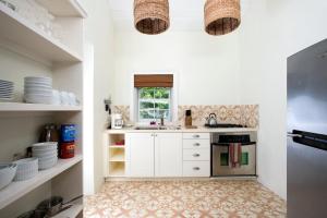 una cucina con mobili bianchi e un lavandino di Buccaneer Hill Cottage cottage a Governorʼs Harbour