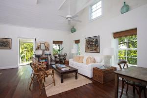 un soggiorno con un divano bianco e un tavolo di Buccaneer Hill Cottage cottage a Governorʼs Harbour