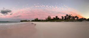a beach with a cloudy sky and the ocean at French Leave South Beach Dogtrot Villa villa in Governorʼs Harbour