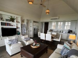 a living room with a couch and a table at French Leave South Beach Dogtrot Villa villa in Governorʼs Harbour +28 photos