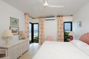 a white bedroom with a bed and a window at Provender home in Savannah Sound +27 photos