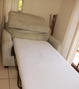 un letto e una sedia in una stanza di Ocean Sounds Cottage cottage a Governorʼs Harbour