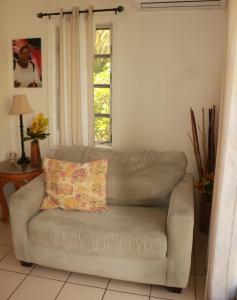 un divano in soggiorno con cuscino di Ocean Sounds Cottage cottage a Governorʼs Harbour