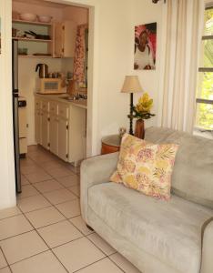 un soggiorno con divano e cucina di Ocean Sounds Cottage cottage a Governorʼs Harbour