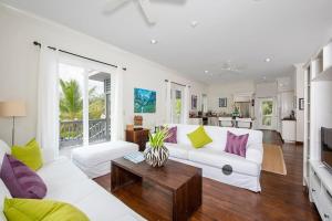 a living room with a white couch and a table at Sand Dollar Cottage cottage in Rock Sound