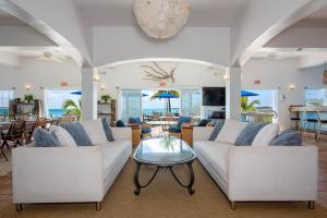 a living room with two white couches and a table at Cocodimama Resort Hotel Room in James Cistern +25 photos