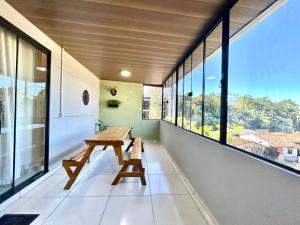 an empty room with a bench and large windows at Casa espaçosa com 3 quartos | Até 11 pessoas in Limeiro +24 photos