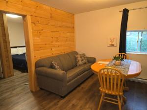 a living room with a couch and a table at Earthquest Lodge in Port Burwell