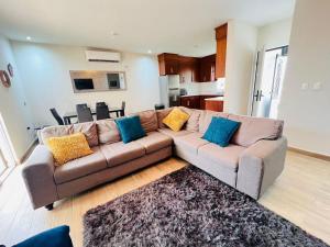 a living room with a brown couch with blue pillows at Charming San Carlos BB with Private Pool BBQ in San Carlos