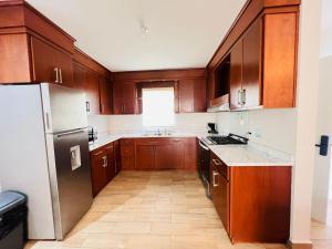 a kitchen with wooden cabinets and a stainless steel refrigerator at Charming San Carlos BB with Private Pool BBQ in San Carlos
