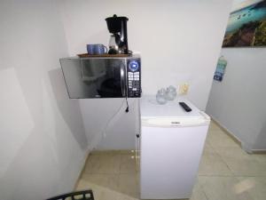 a microwave sitting on top of a white refrigerator at Solares Aconchego - Suíte in Búzios